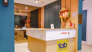 A reception desk with a marble top, wooden paneling, and a 'fab hotels' sign. - Fabhotel Silver Cloud (Mumbai)