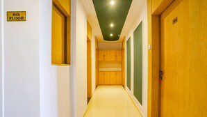 A hallway with a sign indicating the 6th floor, wooden doors, and a green wall. - Fabhotel Silver Cloud (Mumbai)