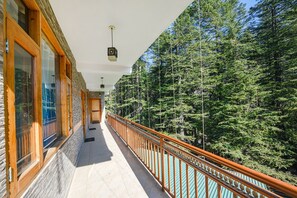 A balcony with a wooden railing overlooking a forested area. - Fabhotel Hadimba Valley (Manali)