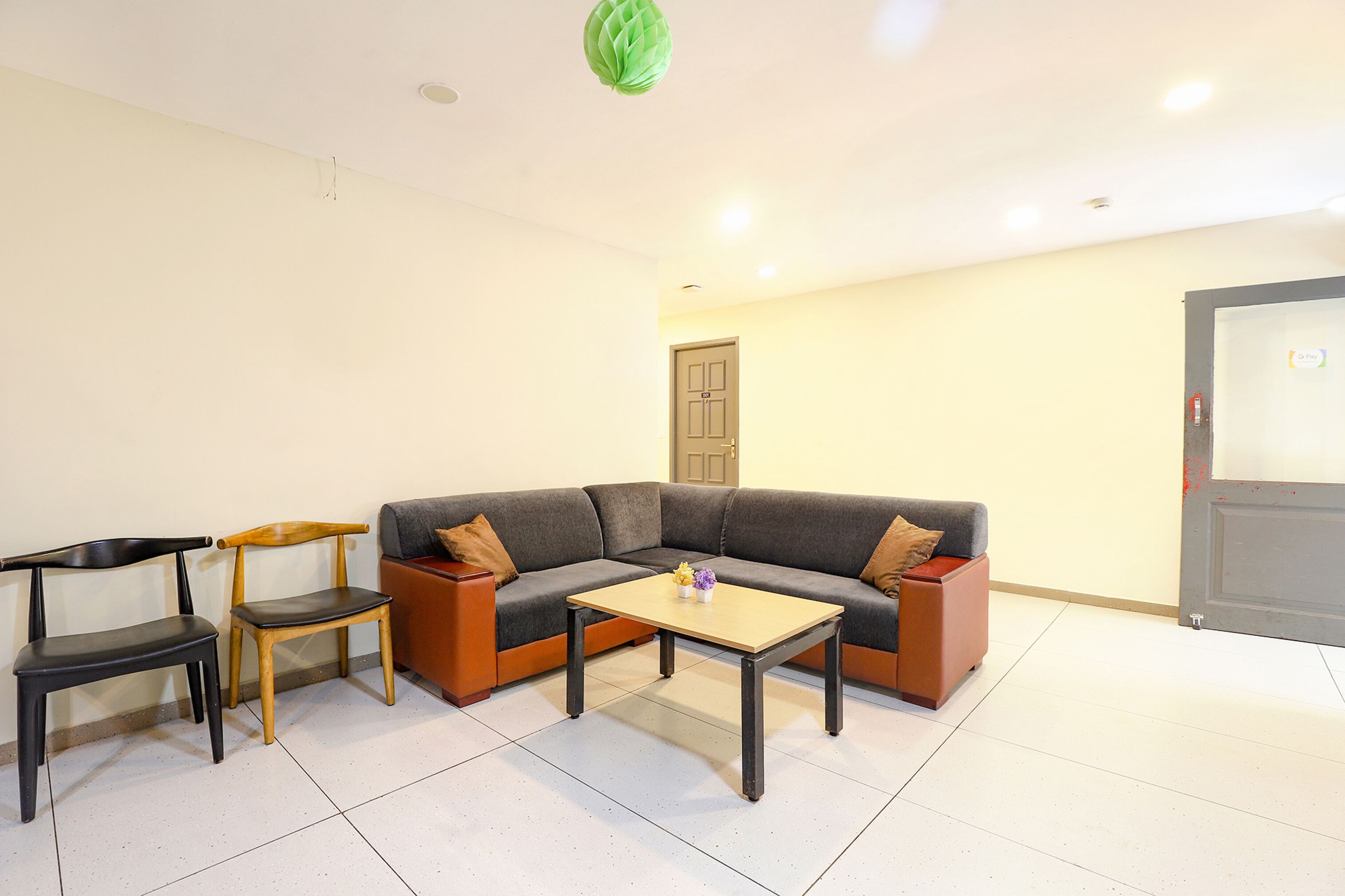 A living room with a sofa, two chairs, a coffee table, and a door.