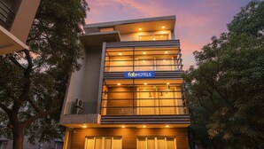A modern multi-story hotel with a prominent 'fabHOTELS' sign, featuring a clean architectural design with large windows and a well-lit facade. - Fabhotel Micasa (Gurugram)