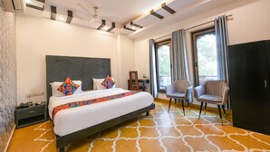 Une chambre d’hôtel moderne équipée d’un grand lit, d’un bureau, de deux chaises et d’une armoire.