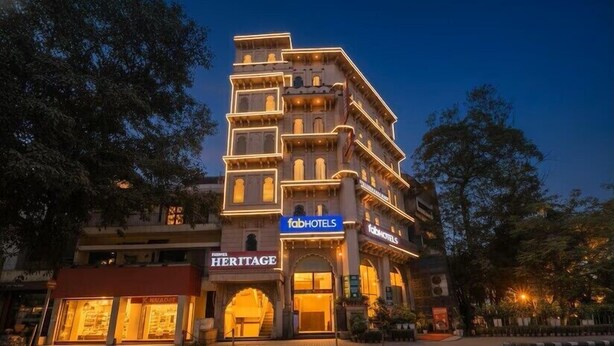 Un immeuble à plusieurs étages, arborant l’enseigne « fabhotels », qui présente un style architectural traditionnel avec de nombreux balcons et une entrée imposante.