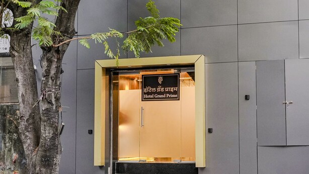 A building entrance with a sign reading "Hotel Grand Prime".