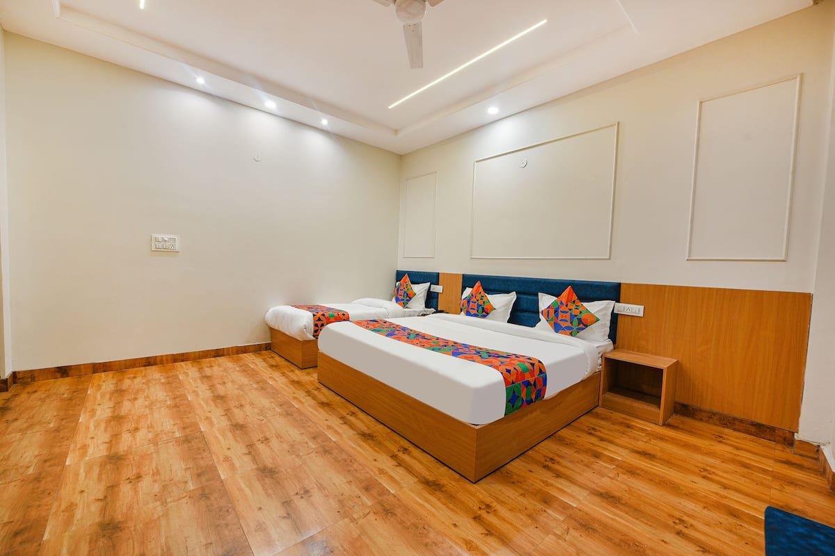 A hotel room with a large bed, a bedside table, and a ceiling fan.