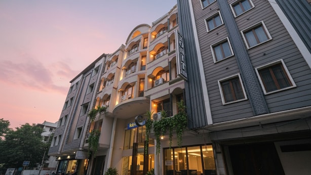 A multi-story hotel with a central atrium, balconies, and a sign indicating a restaurant. - Fabhotel Alpine Tree (Amritsar)