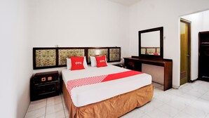 Una habitación de hotel con cama, cómoda, espejo y armario.