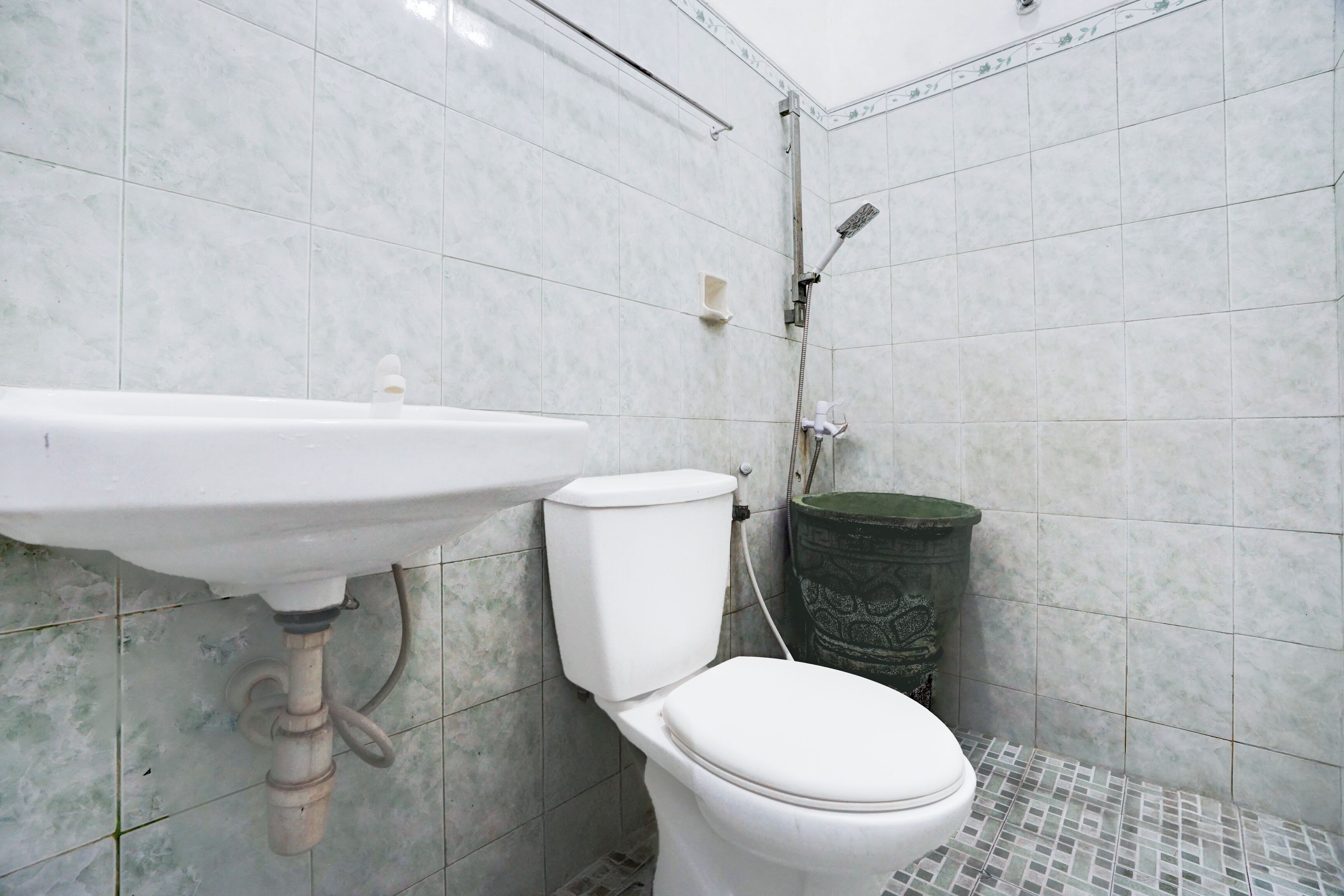Een badkamer met een wit wastafelmeubel, toilet en douche.