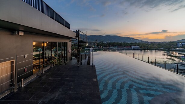 A modern building with a pool and a view of a river and mountains. - Blu Monkey Hub & Hotel Bangtao Beach Phuket (Choeng Thale)