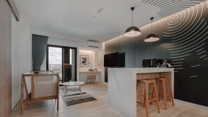 A modern kitchen with a central island, bar stools, a dining area with a table and chairs, and a large window with a view. - Blu Monkey Hub & Hotel Bangtao Beach Phuket (Choeng Thale)