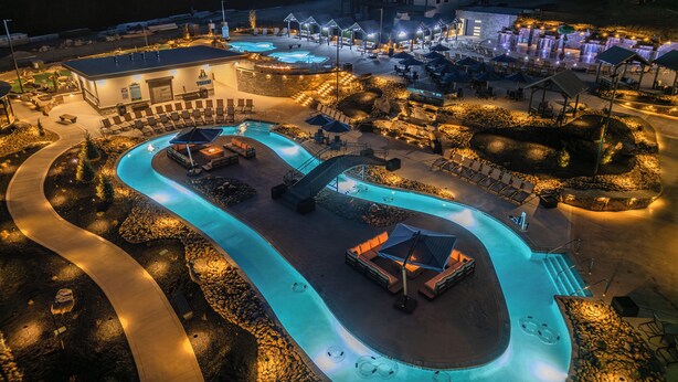 A resort with a large swimming pool, lounge areas, and a building with multiple levels. - WaterPark, LUX, Every Amenity, 3800 sq ft (Sevierville)