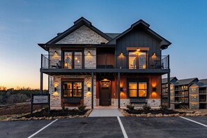 Un bâtiment à deux étages avec une façade en pierre, un balcon à l’étage supérieur et une enseigne indiquant le nom « Smoky Ridge Resort ».