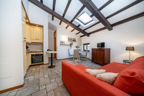 A compact living space with a kitchen, dining area, and a red sofa.