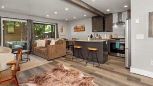 A modern kitchen with a central island, bar stools, and stainless steel appliances. - Stylish Sun Valley 2BR - Dog-Friendly - 2 Min Walk to Town (Ketchum)