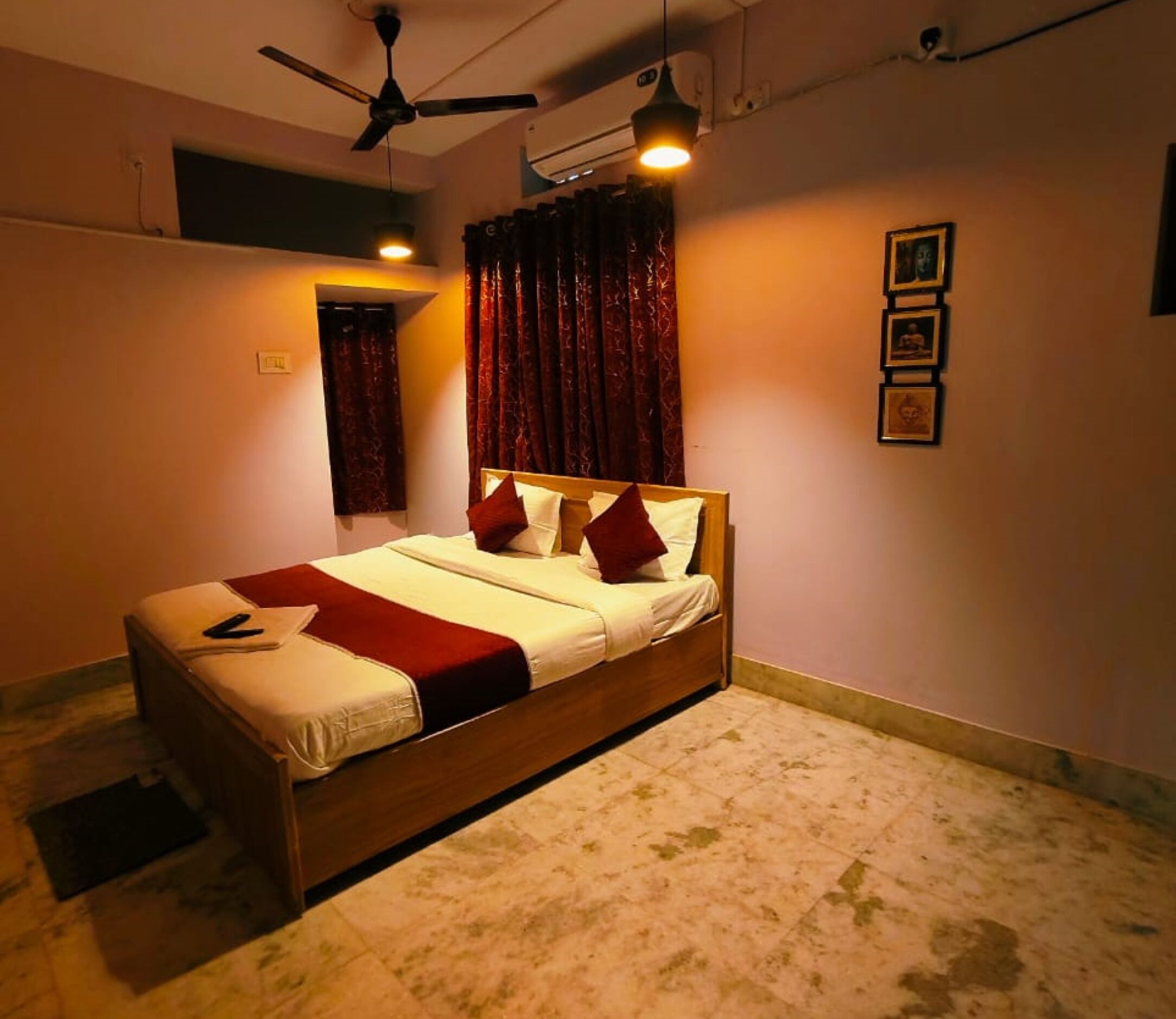 A bedroom with a bed, a ceiling fan, a window with curtains, and a wall-mounted air conditioner.