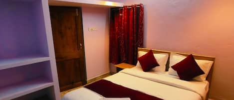A bedroom with a bed, a ceiling fan, a red curtain, and a wooden door.