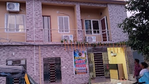 A two-story building with a balcony, air conditioning units, and a sign for a guest house. - Goroomgo Rail View Guest House Puri (Puri)