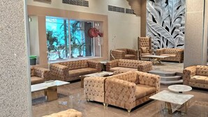 A luxurious lobby with multiple seating areas, a large window with a view, and a decorative wall.