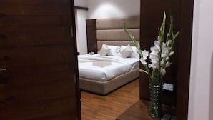 A bedroom with a bed, a nightstand, and a vase with flowers.