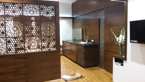 A modern bathroom with a wooden vanity, a large mirror, and a decorative partition.