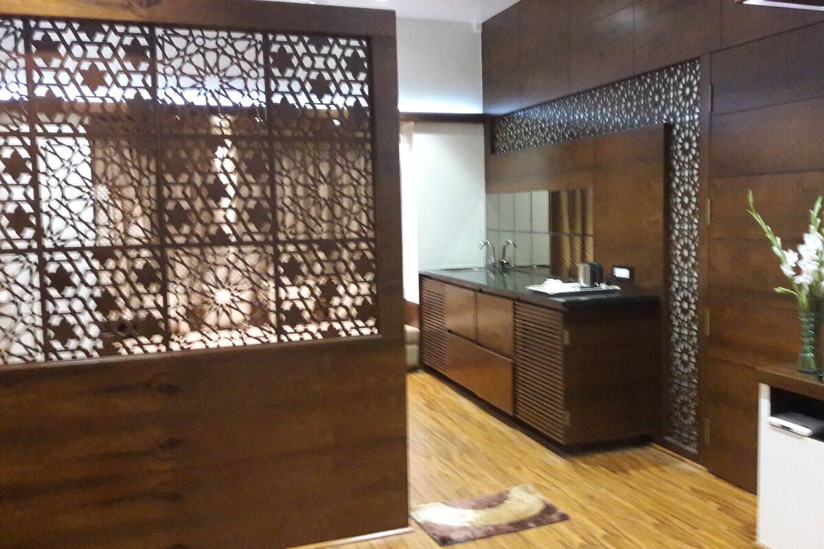 Un baño moderno con tocador de madera, un espejo grande y un panel decorativo.