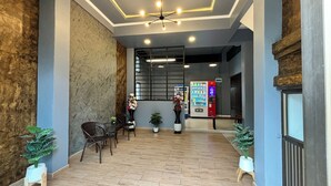 A lobby with a wooden floor, seating area, a vending machine, and a large window. - The Loft Living Space (Samut Prakan)