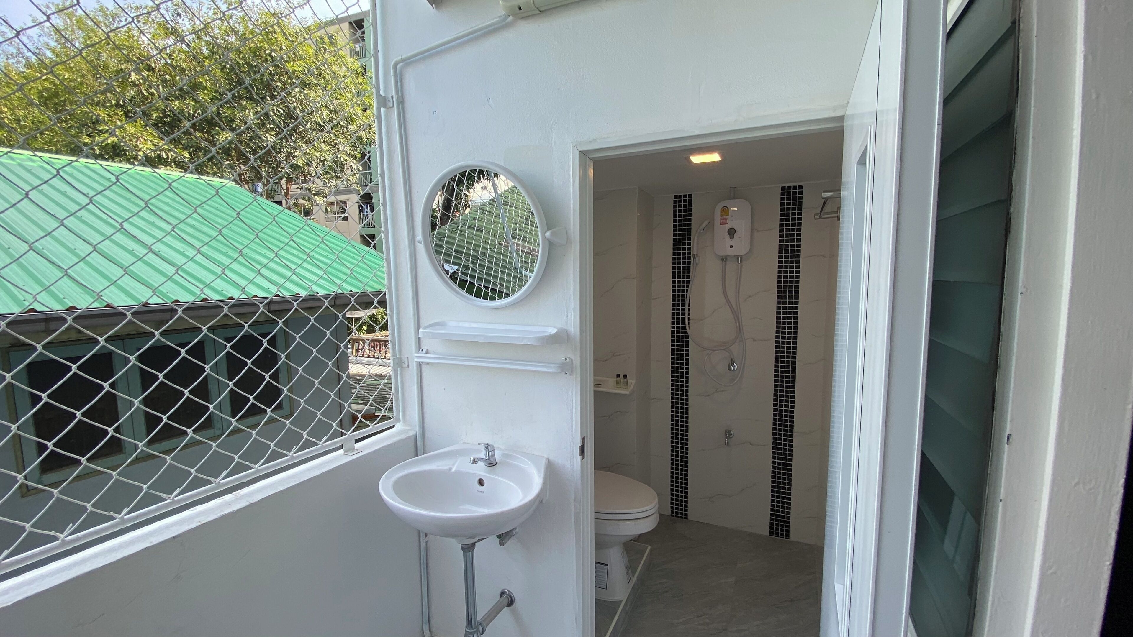 Un baño pequeño y cerrado con inodoro, lavamanos y ducha.