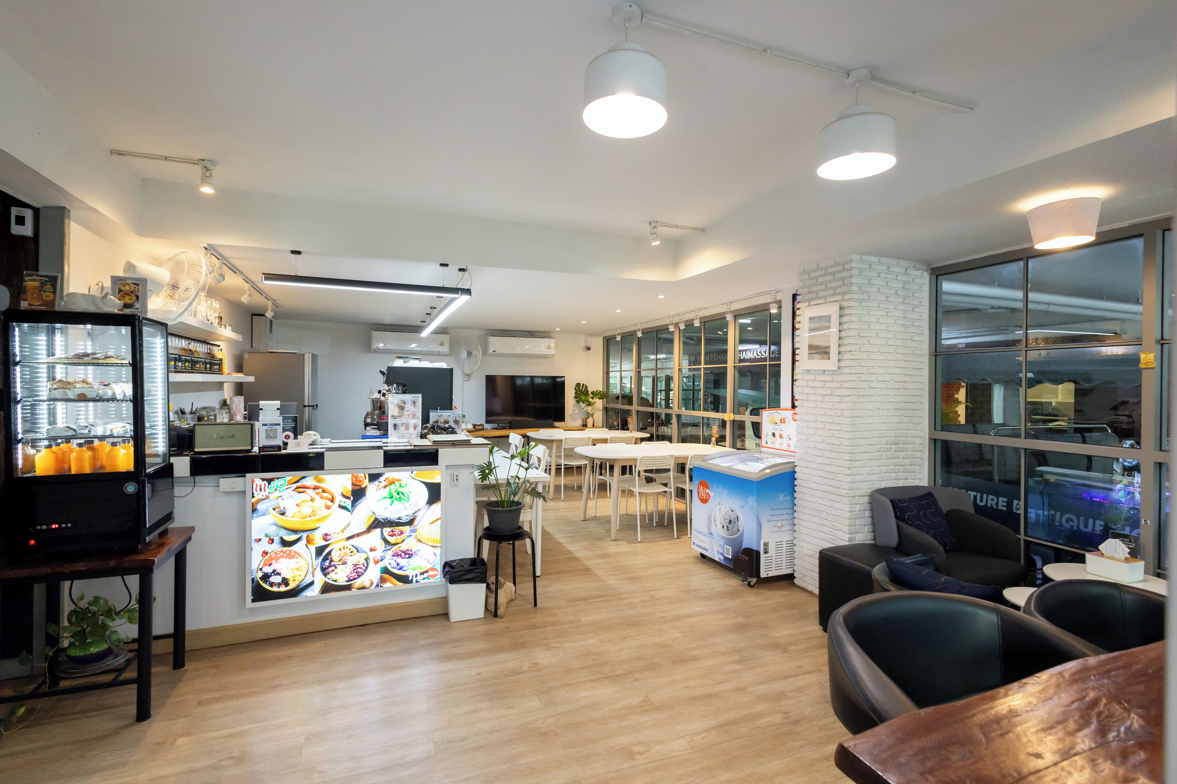 A modern restaurant with a central counter, seating area, and a visible kitchen.