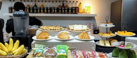 A buffet with various food items, including croissants, sandwiches, and snacks.