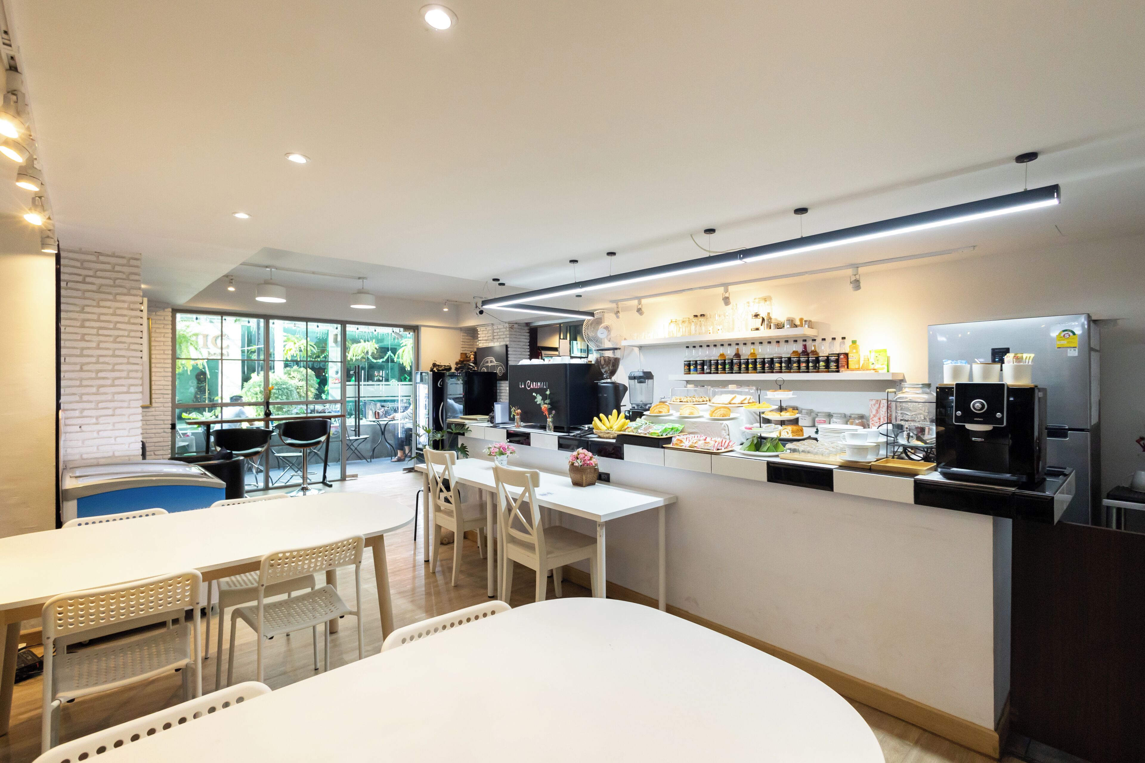 A modern cafe with a bar area, seating, and a coffee machine.