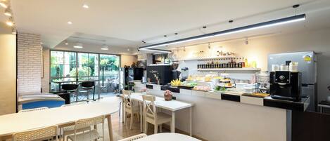 A modern cafe with a bar area, seating, and a coffee machine.