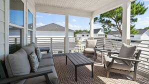 A covered outdoor seating area with a patterned floor, a sofa, a chair, and a table. - 🦩Book Me Baby! Pray For Sun~Private Home at Inlet Beach🦩 (Inlet Beach)