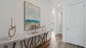 A hallway with a marble console table, abstract art, and a staircase. - 🦩Book Me Baby! Pray For Sun~Private Home at Inlet Beach🦩 (Inlet Beach)