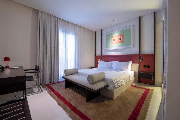 A modern hotel room with a large bed, a desk, and a chair. - Rhb Qurtubah - رحب قرطبة (Riyadh)