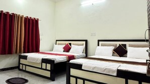 A hotel room with two beds, a marble floor, and a ceiling with circular light fixtures. - Goroomgo Shivaay Ayodhya (Faizabad)