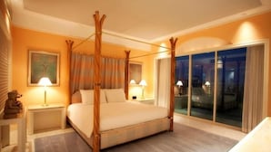 Una cama con dosel en una habitación de hotel con vistas a la ciudad de noche.