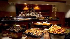 Un bufé con diversos platos, incluyendo mariscos y opciones fritas, en un restaurante.