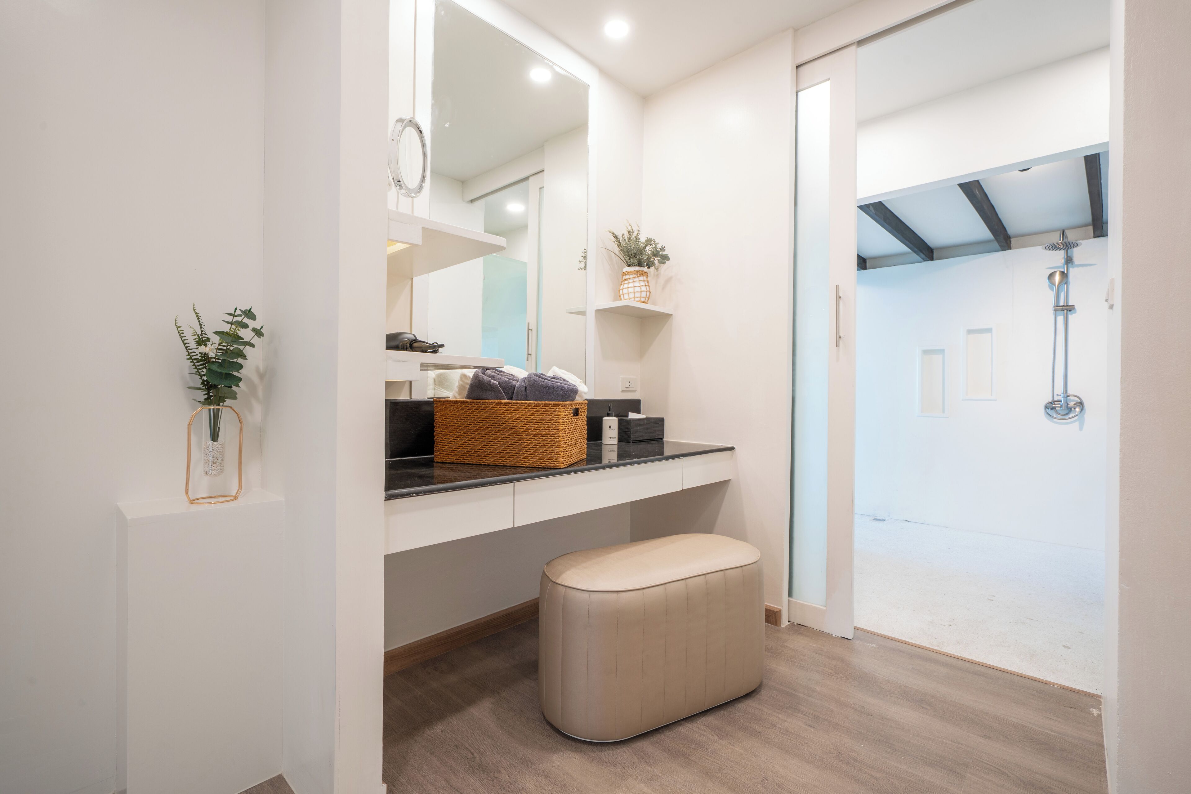 Un baño moderno con espejo, lavamanos y zona de ducha.