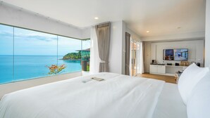 A hotel room with a large bed, a TV, and a view of the ocean. - Anona Sunset Boutique (Karon)
