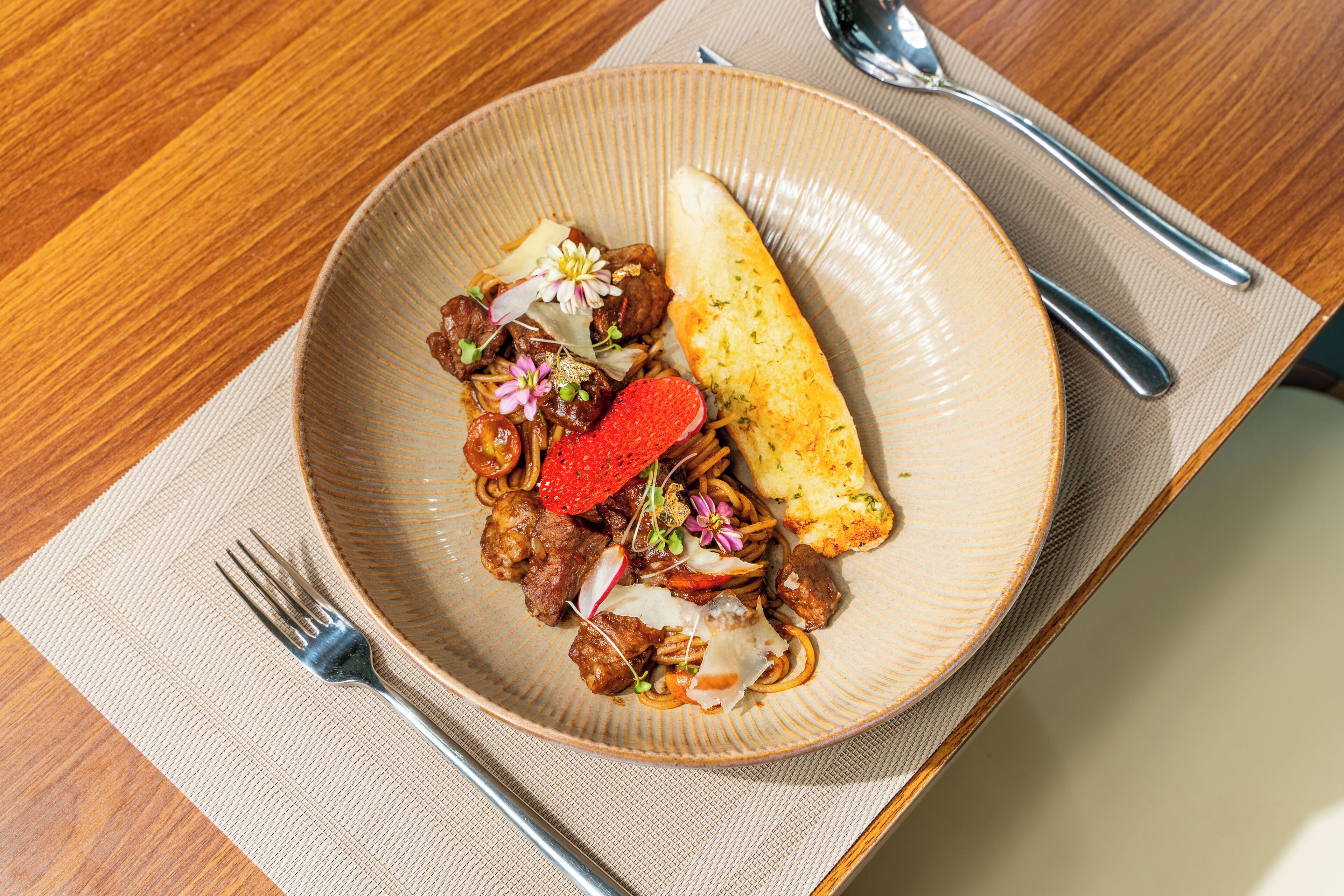 A plate of food with a fork and spoon on a table.