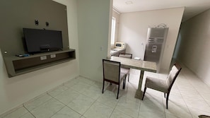 A compact kitchen with a TV, a microwave, and a refrigerator. - Casa Para sua Viajem em Foz do Iguaçu (Foz do Iguaçu)