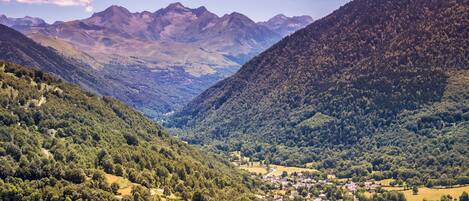 Une vallée où se trouve une petite ville, nichée au milieu de collines et de montagnes verdoyantes.