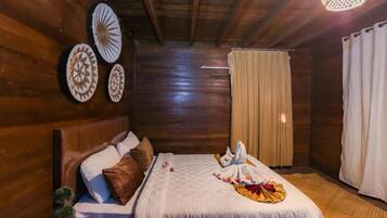 A wooden room with a bed, a headboard, and a ceiling fan.