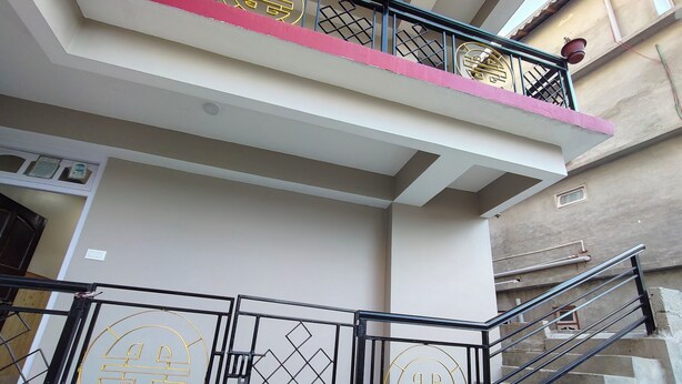 A staircase with a metal railing and a decorative gate at the bottom. - Hotel Wanderlusts Rigyal Lachung (Chungthang)
