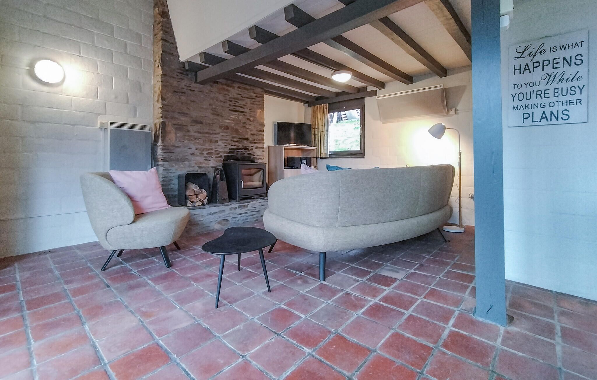A cozy living room with a fireplace, two sofas, and a small table.