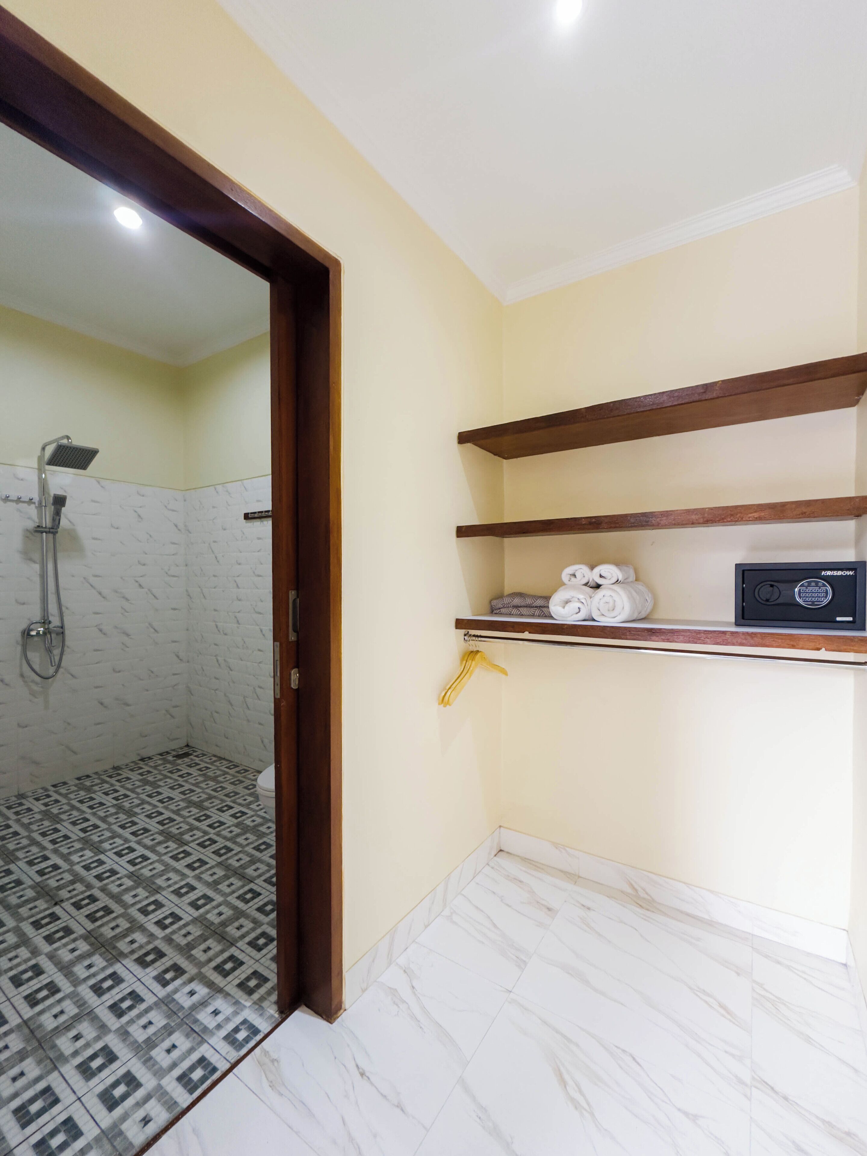 A bathroom with a shower, a toilet, and a towel rack with towels.