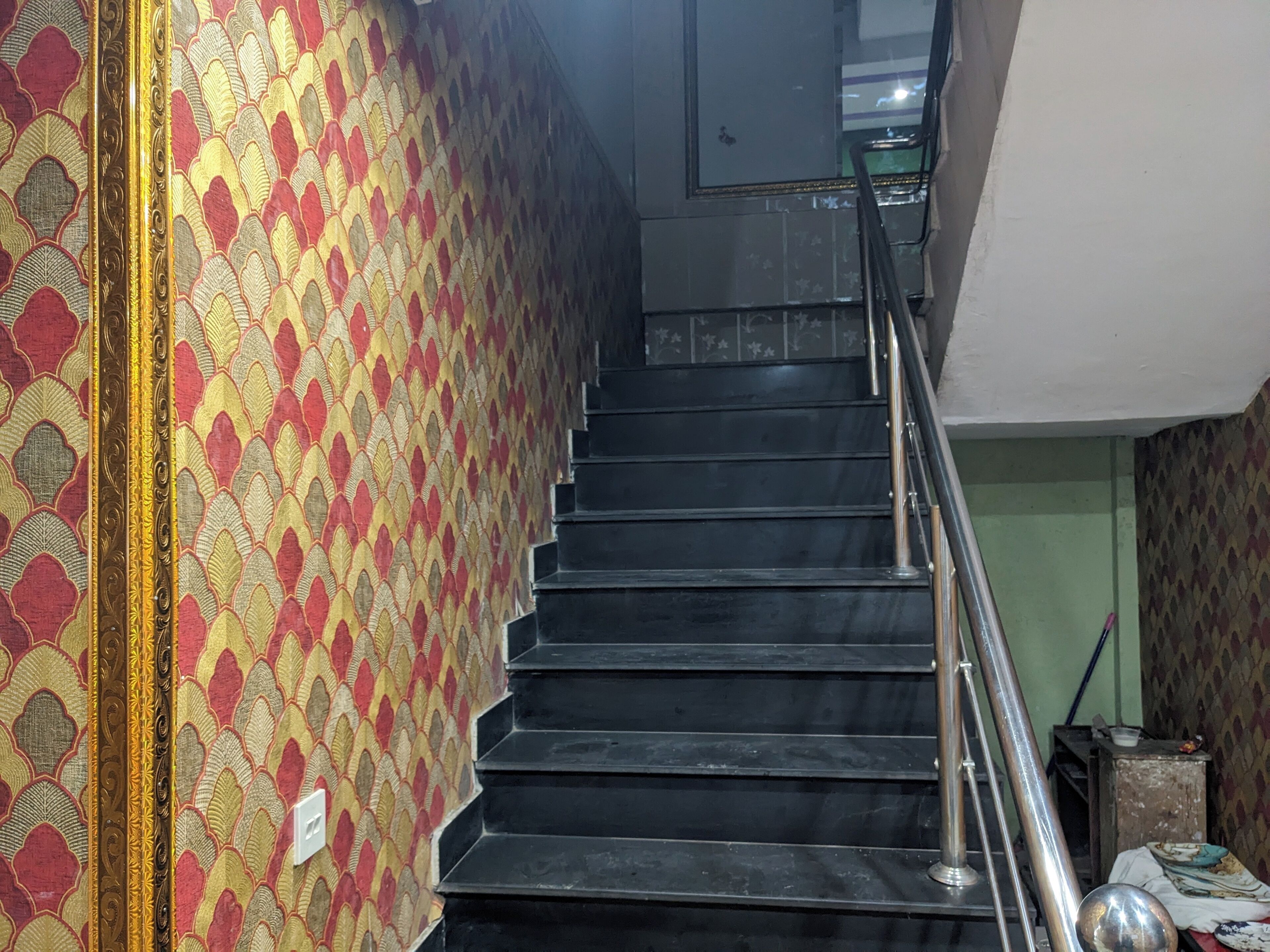 A staircase with a patterned wall on one side and a plain wall on the other.