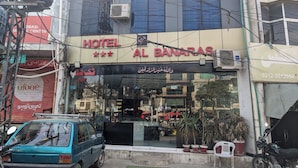 A hotel named "Hotel Al Banaras" with a signboard, a parked car, and potted plants in front. - Al-Banaras Hotel  (Rawalpindi)