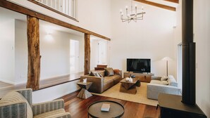 A modern living room with a large TV, comfortable seating, and a fireplace. - The Vintners: Where luxury meets nature, five master suites & spacious living (Peerabeelup)