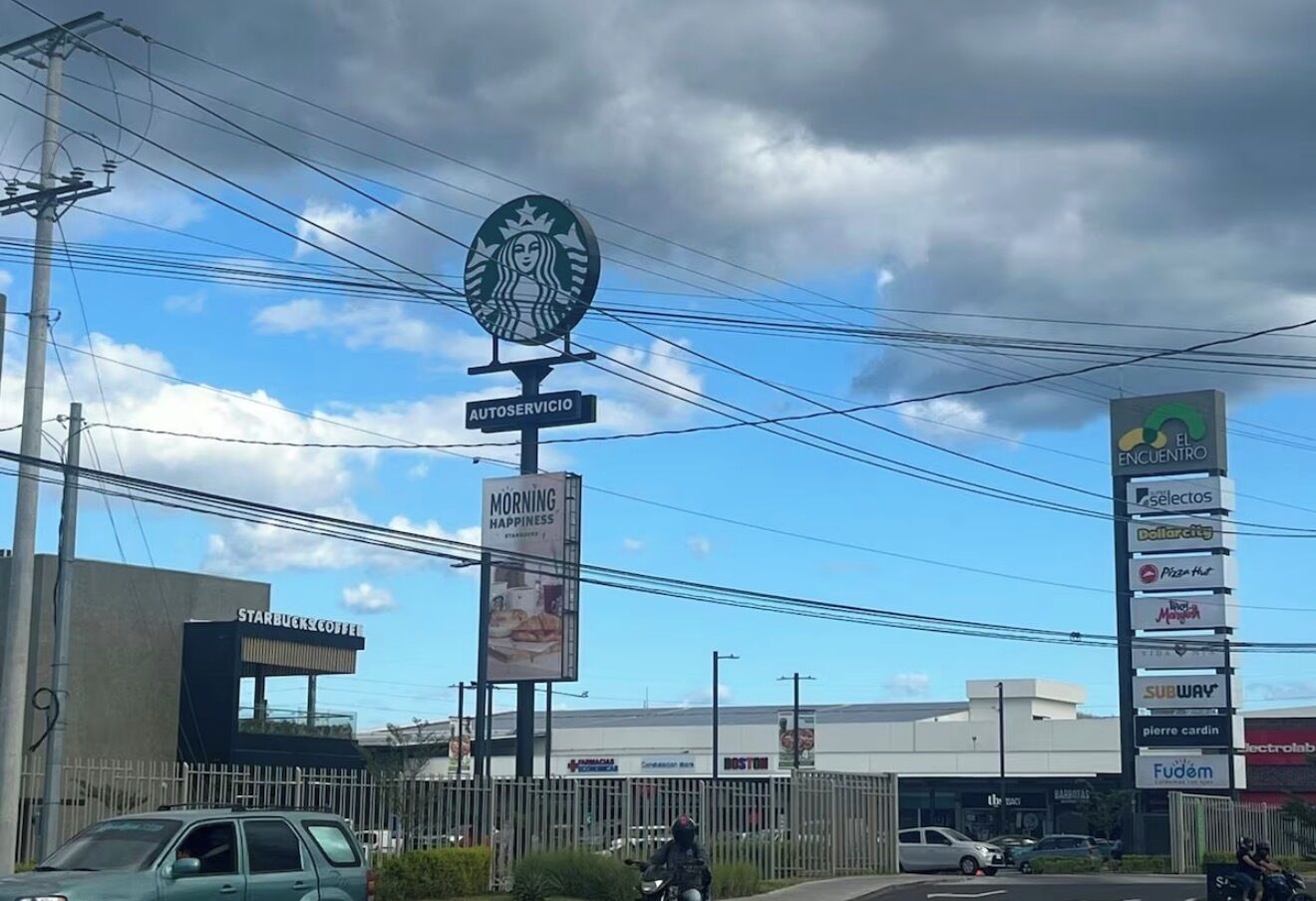 Een Starbucks Coffee bord, een bord met de tekst 'MORNING HAPPINESS' en een bord met verschillende winkels zoals Subway en Pizza Hut.